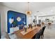 Elegant dining room with a blue accent wall, modern light fixture, and open layout to the kitchen at 4522 Tramanto Ln, Wesley Chapel, FL 33543