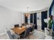 Chic dining room with stylish chairs, wood table, modern light fixture and blue accent wall at 4522 Tramanto Ln, Wesley Chapel, FL 33543