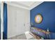 Stylish entryway with a vibrant blue accent wall, decorative table, and a rustic wooden mirror at 4522 Tramanto Ln, Wesley Chapel, FL 33543