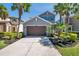 Inviting two-story home with blue shutters, a two-car garage, and lush, manicured landscaping with mature palm trees at 4522 Tramanto Ln, Wesley Chapel, FL 33543