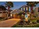 Exterior elevation of a two-story home with a well-manicured lawn, palm trees, and blue shutters at 4522 Tramanto Ln, Wesley Chapel, FL 33543