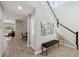 Inviting foyer with wood-look tile flooring, staircase, and a decorative bench adding a touch of elegance at 4522 Tramanto Ln, Wesley Chapel, FL 33543