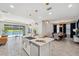 Bright kitchen island featuring a stainless steel sink, pendant lights, and a view of the water from the sliding glass doors at 4522 Tramanto Ln, Wesley Chapel, FL 33543