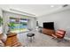 The open living space with a brown leather couch, dark flooring and sliding doors offer great views of the water at 4522 Tramanto Ln, Wesley Chapel, FL 33543