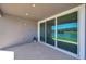 Covered patio featuring sliding glass doors that offer a tranquil view of the pond at 4522 Tramanto Ln, Wesley Chapel, FL 33543