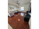 Living room boasting glossy hardwood floors, TV, large windows and fan at 4632 Chatterton Way, Riverview, FL 33578