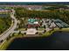 Aerial view of the lakefront community clubhouse, pool, and tennis courts at 4896 San Martino Dr, Wesley Chapel, FL 33543