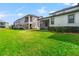 Green backyard featuring a spacious lawn and views of neighboring townhomes at 4896 San Martino Dr, Wesley Chapel, FL 33543