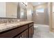 Bathroom features double sinks with granite countertops, dark cabinetry, and a tiled shower-tub combo at 4896 San Martino Dr, Wesley Chapel, FL 33543