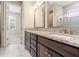 Bathroom with granite countertops, double vanity, and a glass-enclosed shower at 4896 San Martino Dr, Wesley Chapel, FL 33543