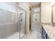 Well-lit bathroom with walk-in shower, granite countertops, and white-tile flooring at 4896 San Martino Dr, Wesley Chapel, FL 33543