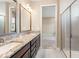 Modern bathroom featuring double vanity with granite countertops and a glass-enclosed shower at 4896 San Martino Dr, Wesley Chapel, FL 33543
