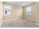Bright bedroom with neutral carpeting, base trim, and well-lit windows offering neighborhood views at 4896 San Martino Dr, Wesley Chapel, FL 33543