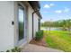 Exterior side view of a home featuring a door, garden, green lawn and a lake in the background at 4896 San Martino Dr, Wesley Chapel, FL 33543