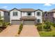 Charming two-story townhouse featuring a brick-paved driveway and a two-car garage at 4896 San Martino Dr, Wesley Chapel, FL 33543
