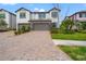 View of a modern two-story townhouse featuring a two-car garage and landscaped front yard at 4896 San Martino Dr, Wesley Chapel, FL 33543