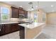 Well-lit kitchen featuring an island, stainless steel appliances, and dark wood cabinets at 4896 San Martino Dr, Wesley Chapel, FL 33543