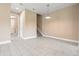 Spacious living area with tile flooring and view to the staircase and laundry room area at 4896 San Martino Dr, Wesley Chapel, FL 33543
