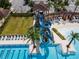 Aerial of community pool showcasing a slide, lounge chairs, palm trees, and a pergola at 4896 San Martino Dr, Wesley Chapel, FL 33543
