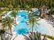 Aerial view of community pool surrounded by palm trees, lounge chairs, and a water slide at 4896 San Martino Dr, Wesley Chapel, FL 33543