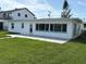 Inviting home with a spacious backyard, featuring a tiled patio and lush lawn at 525 Crystal Dr, Madeira Beach, FL 33708