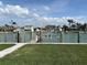 Lush backyard space with access to a canal, featuring a boat lift, and picturesque water views at 525 Crystal Dr, Madeira Beach, FL 33708