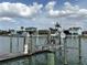 Picturesque canal view showcasing boat lifts and stunning waterfront residences against a cloudy sky at 525 Crystal Dr, Madeira Beach, FL 33708
