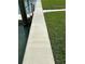 A concrete dockside walkway is adjacent to a pier, with lush green grass adding a welcoming touch at 525 Crystal Dr, Madeira Beach, FL 33708