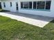 Exterior view of a gray paver patio and green lawn outside a white home near a canal at 525 Crystal Dr, Madeira Beach, FL 33708