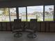 A light-filled sun room with chairs overlooks a canal with docks, boats, and waterfront homes at 525 Crystal Dr, Madeira Beach, FL 33708