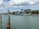 Scenic view of homes with docks along a waterway, framed by clear blue skies and fluffy clouds at 525 Crystal Dr, Madeira Beach, FL 33708