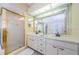 Bright bathroom features double sinks, a large mirror, and a separate shower with gold trim at 5342 Sagamore Ct, New Port Richey, FL 34655
