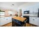 Kitchen with white cabinets, granite countertops, a central island, and modern appliances, ideal for cooking at 5342 Sagamore Ct, New Port Richey, FL 34655