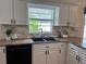 Kitchen with granite countertops, white cabinets, undermounted sink and black hardware at 5342 Sagamore Ct, New Port Richey, FL 34655