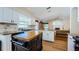 Kitchen with wooden floors and island, granite counters, and white cabinets at 5342 Sagamore Ct, New Port Richey, FL 34655