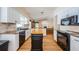 Bright kitchen featuring white cabinets, black appliances, granite countertops and a central island at 5342 Sagamore Ct, New Port Richey, FL 34655
