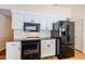 Modern kitchen featuring black appliances, granite countertops, and white cabinets at 5342 Sagamore Ct, New Port Richey, FL 34655