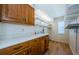 Well-organized laundry room featuring wood cabinets, ample counter space, and convenient shelving for storage at 5342 Sagamore Ct, New Port Richey, FL 34655