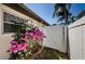Side yard featuring a white fence, lush flowering plants, and easy access at 5342 Sagamore Ct, New Port Richey, FL 34655