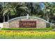 A welcoming entrance to Fish Hawk Ranch with stone signage and colorful landscaping creating an inviting first impression at 5610 Tanagergrove Way, Lithia, FL 33547