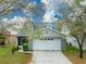 Charming home featuring a two-car garage, gray exterior, and well-manicured lawn at 5610 Tanagergrove Way, Lithia, FL 33547