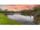 Scenic shot of pond at sunset with red and pink clouds reflecting in the water at 5610 Tanagergrove Way, Lithia, FL 33547