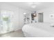 Bright bedroom featuring a mounted TV, white decor, and water view at 5850 Gasparilla Rd # M5, Boca Grande, FL 33921
