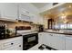 Well-lit kitchen with white cabinetry, modern appliances, and a stylish black and white backsplash at 6269 Palma Del Mar S Blvd # 111, St Petersburg, FL 33715