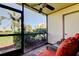 Relaxing screened-in patio with ceiling fan and comfortable wicker furniture with a view of lush greenery at 6269 Palma Del Mar S Blvd # 111, St Petersburg, FL 33715