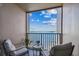 Cozy balcony features comfortable seating, water views, and a charming glass top table at 634 Edgewater Dr # 744, Dunedin, FL 34698