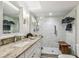 Luxurious bathroom featuring marble tile walls, a glass shower, and granite countertops at 634 Edgewater Dr # 744, Dunedin, FL 34698