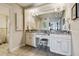 Bright bathroom with granite countertops, dual sinks, decorative mirrors, and vanity seating at 634 Edgewater Dr # 744, Dunedin, FL 34698