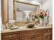 Elegant bathroom vanity featuring a vessel sink, granite countertop, and decorative gold-framed mirror at 634 Edgewater Dr # 744, Dunedin, FL 34698
