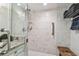 Updated bathroom with marble tile walls, a glass shower door, and modern fixtures at 634 Edgewater Dr # 744, Dunedin, FL 34698